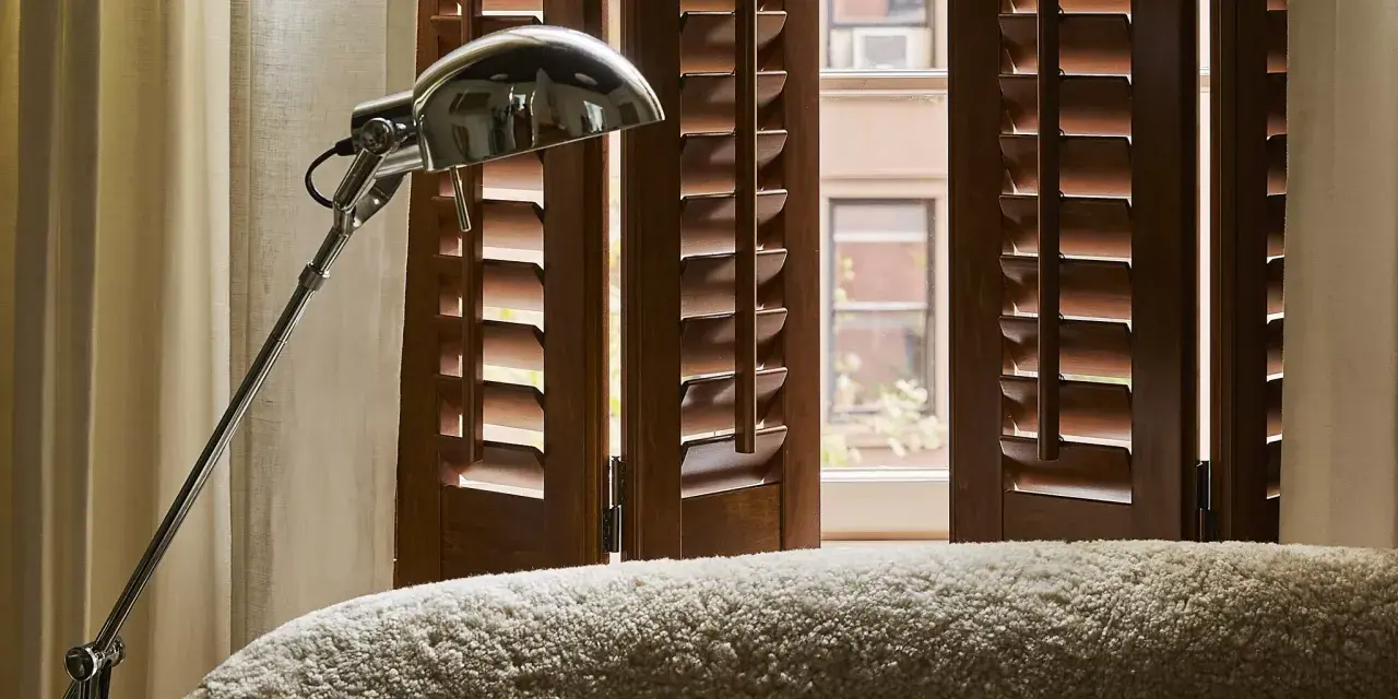 Custom dark wood shutters paired with drapes